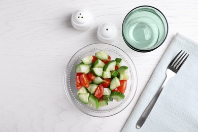 Photo of Flat lay composition with delicious fresh cucumber tomato salad on table, space for text