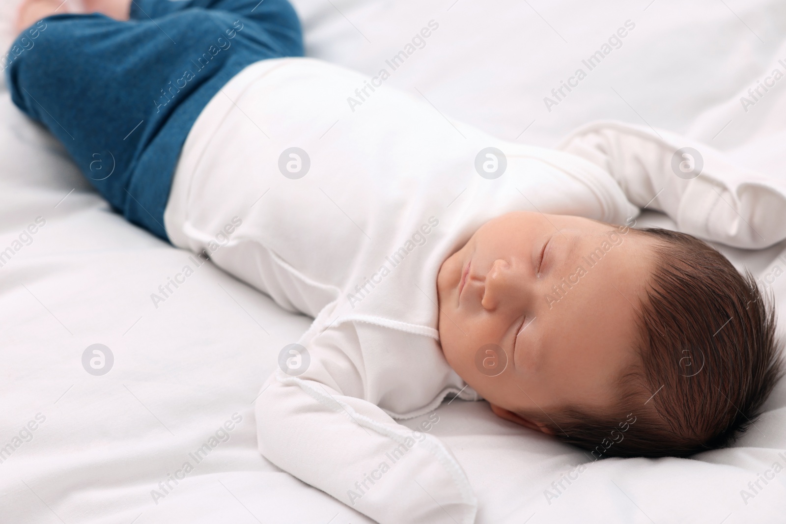 Photo of Cute newborn baby sleeping on white soft bed