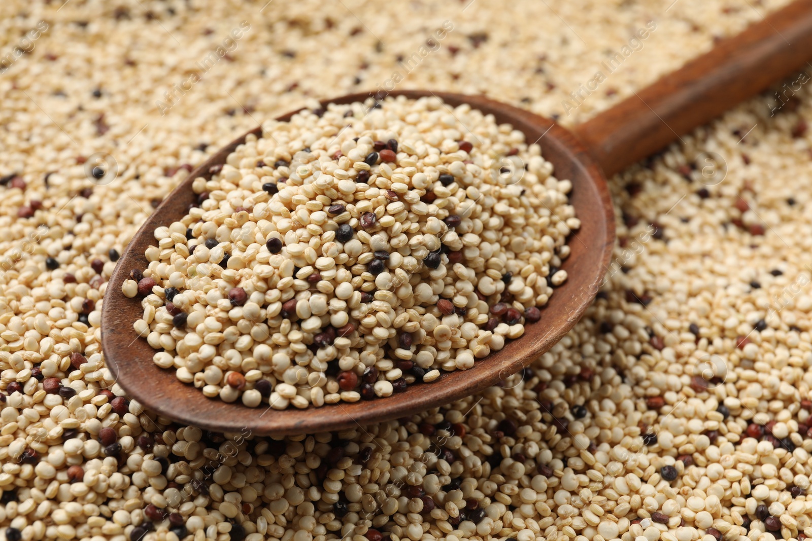 Photo of Heap of raw quinoa seeds and spoon, closeup