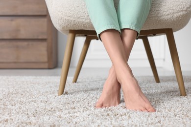 Woman on soft light brown carpet at home, closeup. Space for text