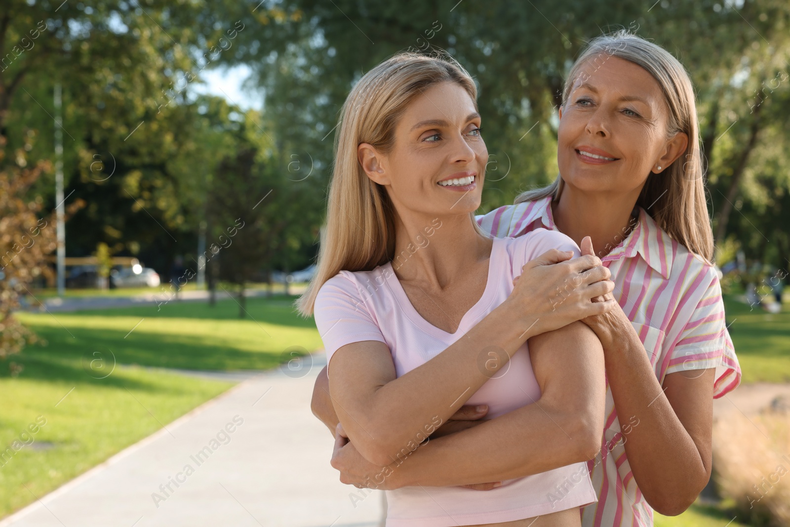 Photo of Family portrait of mother and daughter in park, space for text