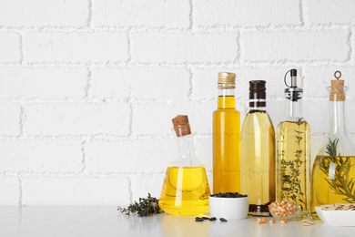 Photo of Different cooking oils on white table. Space for text