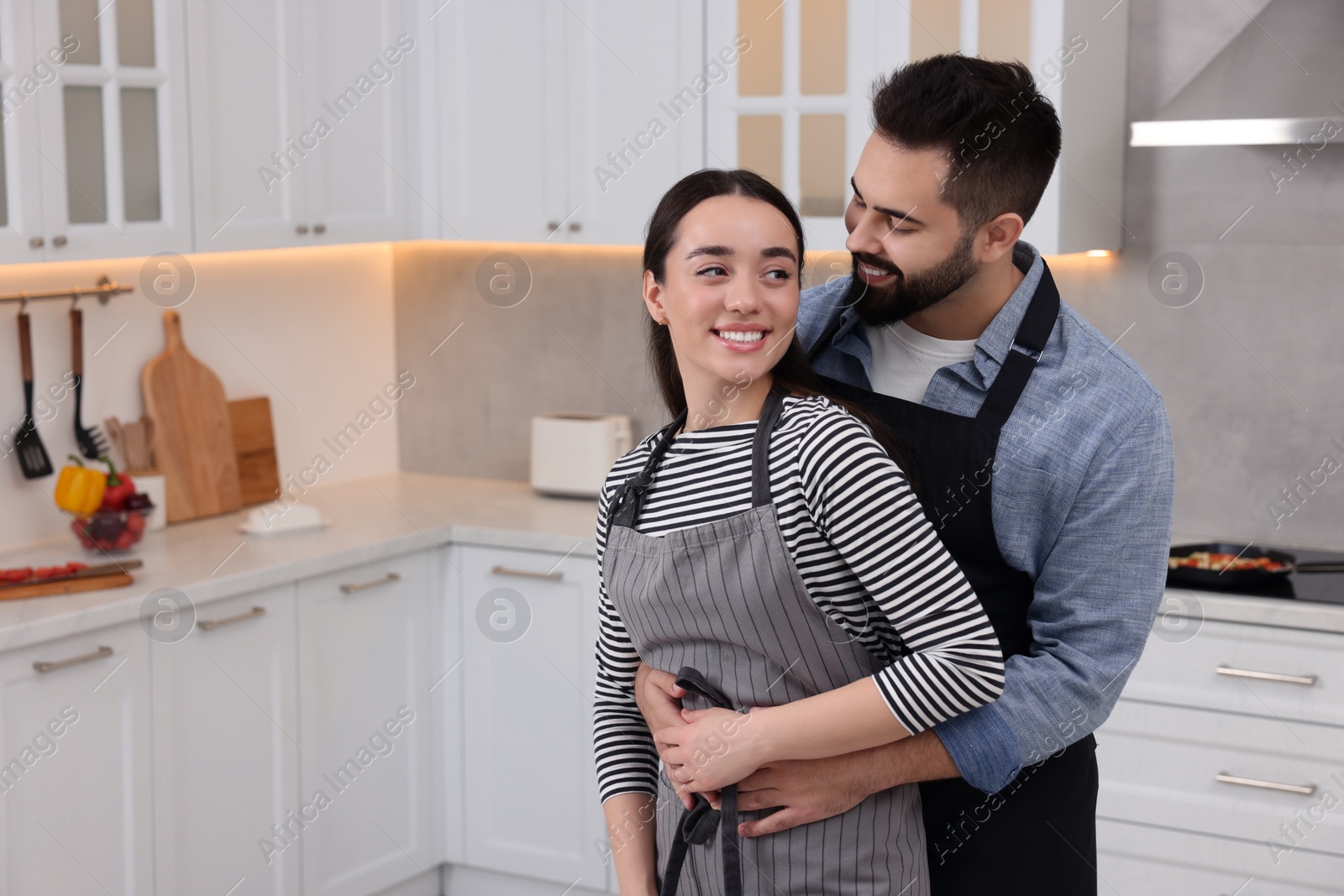 Photo of Lovely couple enjoying time together in kitchen, space for text