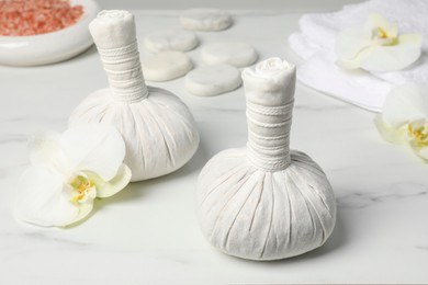 Photo of Spa bags and orchid flowers on white marble table