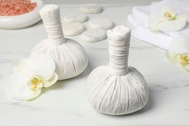 Spa bags and orchid flowers on white marble table