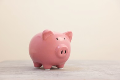 Photo of Pink piggy bank on grey table, space for text