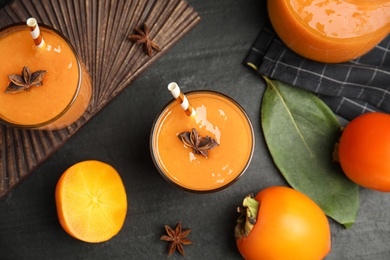 Photo of Tasty persimmon smoothie with anise and fresh fruits on black table, flat lay