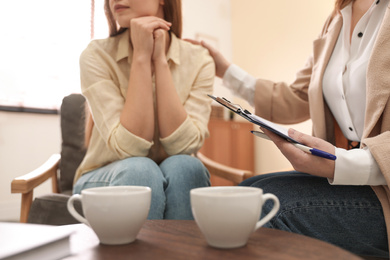 Photo of Professional psychotherapist working with patient in office, closeup