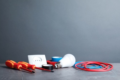 Set of electrician's tools on table against gray background. Space for text