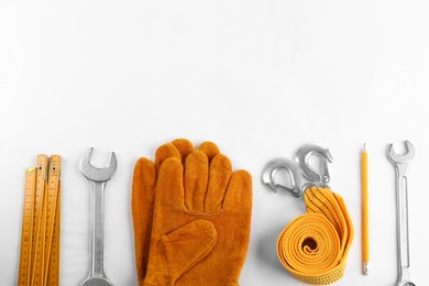 Photo of Flat lay composition with construction tools and safety equipment on white background. Space for text