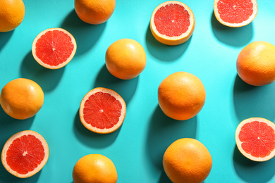 Cut and whole ripe grapefruits on blue background, flat lay