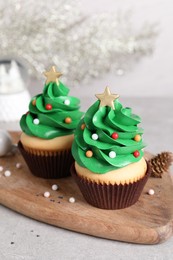 Photo of Christmas tree shaped cupcakes on light grey table