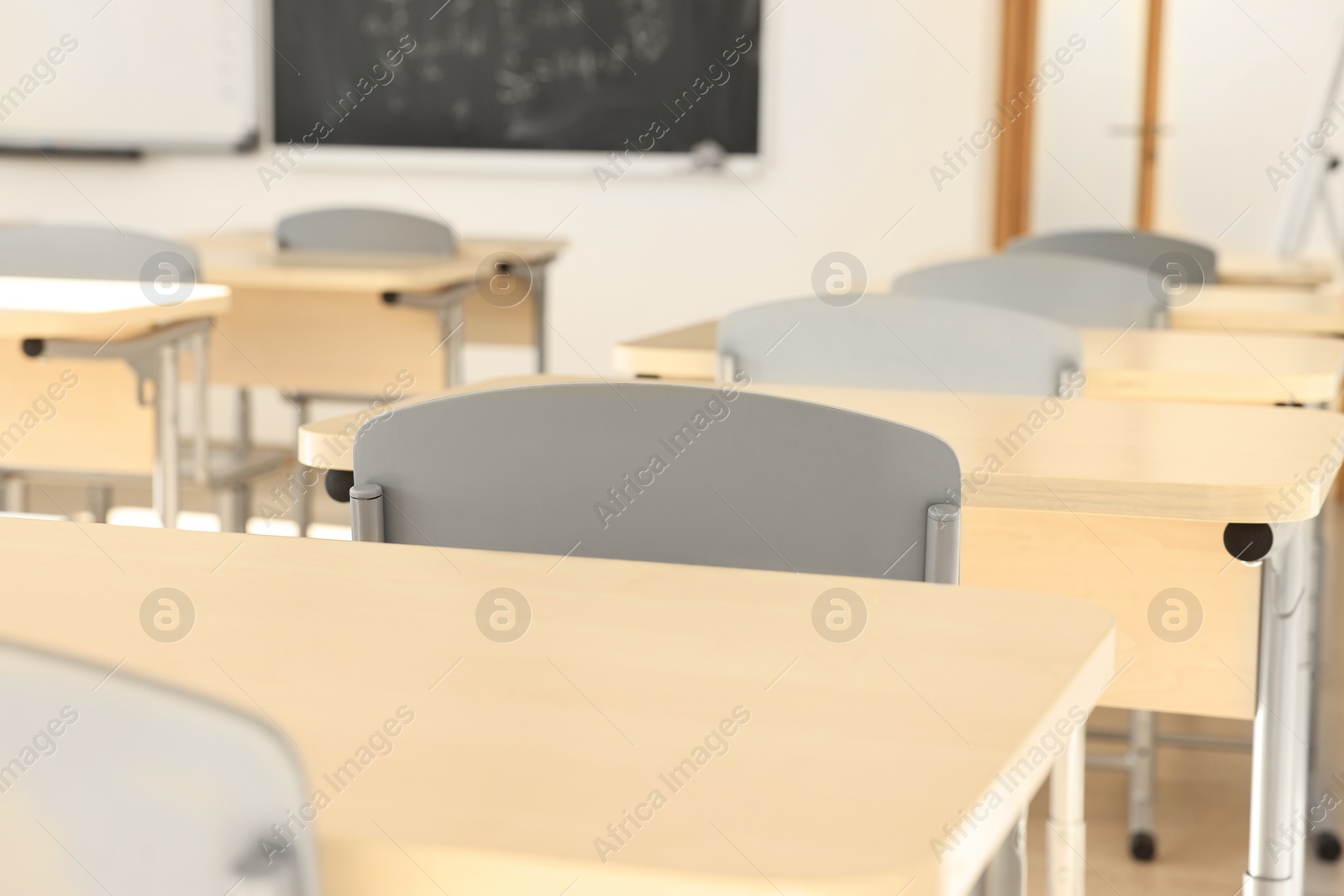 Photo of Empty school classroom with desks and chairs