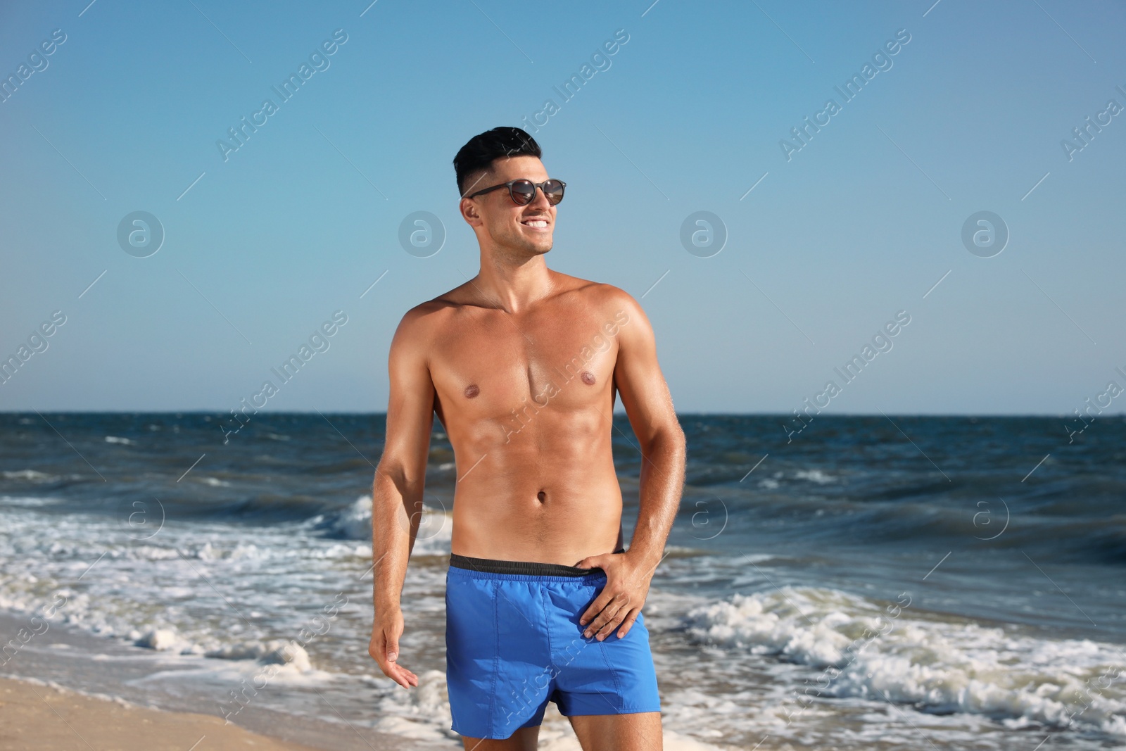 Photo of Handsome man with attractive body on beach