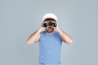 Photo of Sailor with binoculars on light grey background