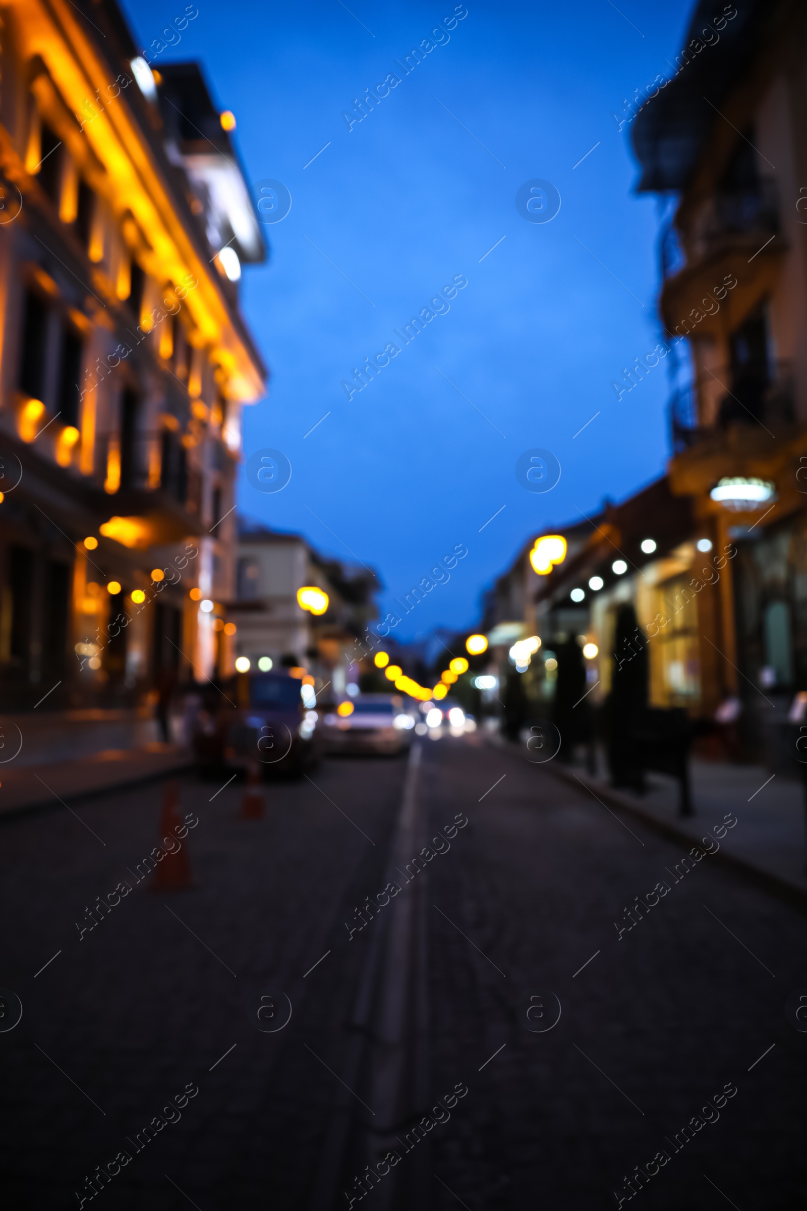 Photo of Blurred view of beautiful cityscape with glowing streetlights and illuminated building in evening