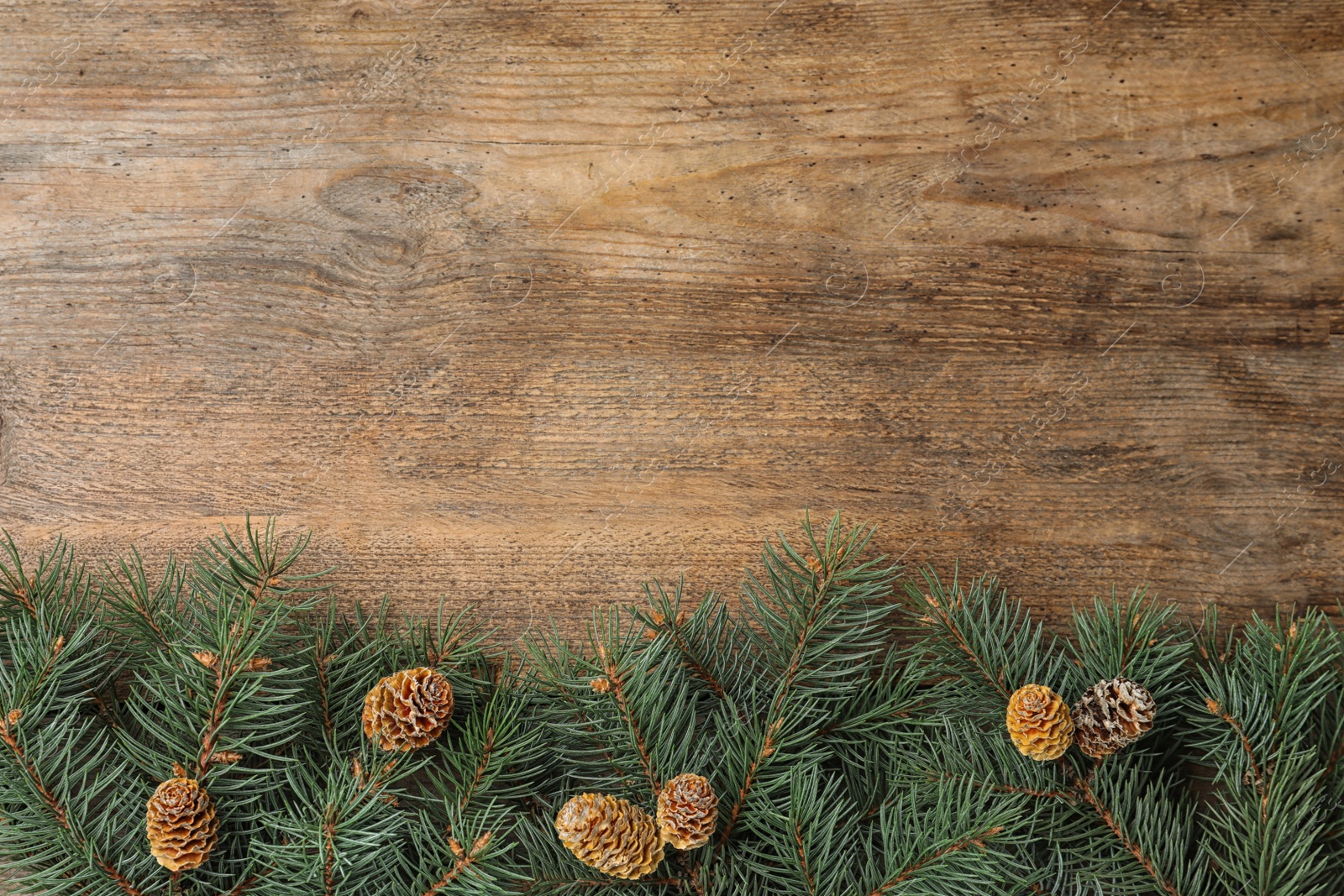Photo of Top view of fir branches on wooden background, space for text. Winter holidays