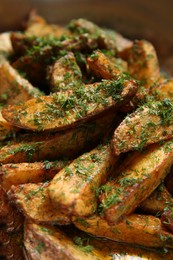 Photo of Delicious oven baked potatoes with dill in container, closeup