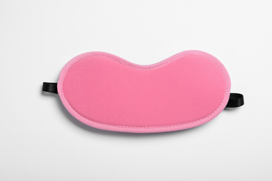 Photo of Pink sleeping mask isolated on white, top view. Bedtime accessory