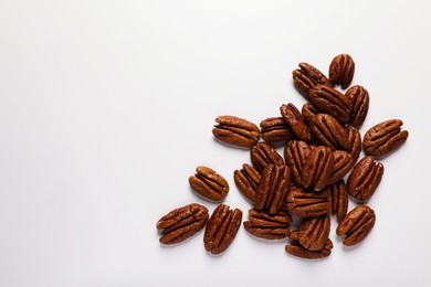 Pile of delicious fresh pecan nuts on white background, flat lay. Space for text