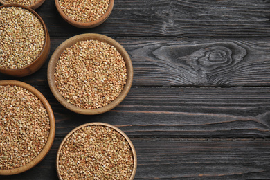 Flat lay composition with green buckwheat on black wooden table. Space for text