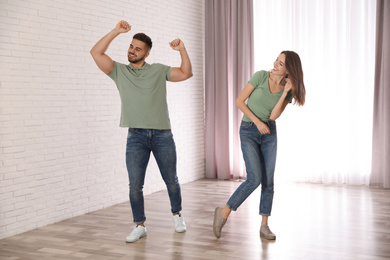 Lovely young couple dancing together at home