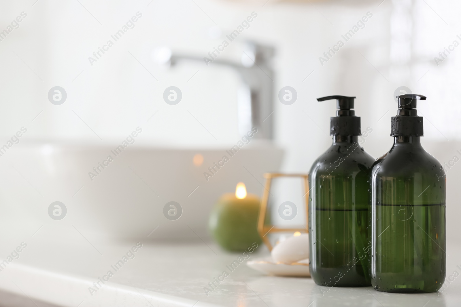 Photo of Green soap dispensers on countertop near sink in bathroom. Space for text