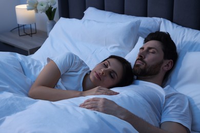 Photo of Lovely couple sleeping together in bed at night