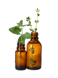 Photo of Bottle of essential oil with mint and thyme isolated on white