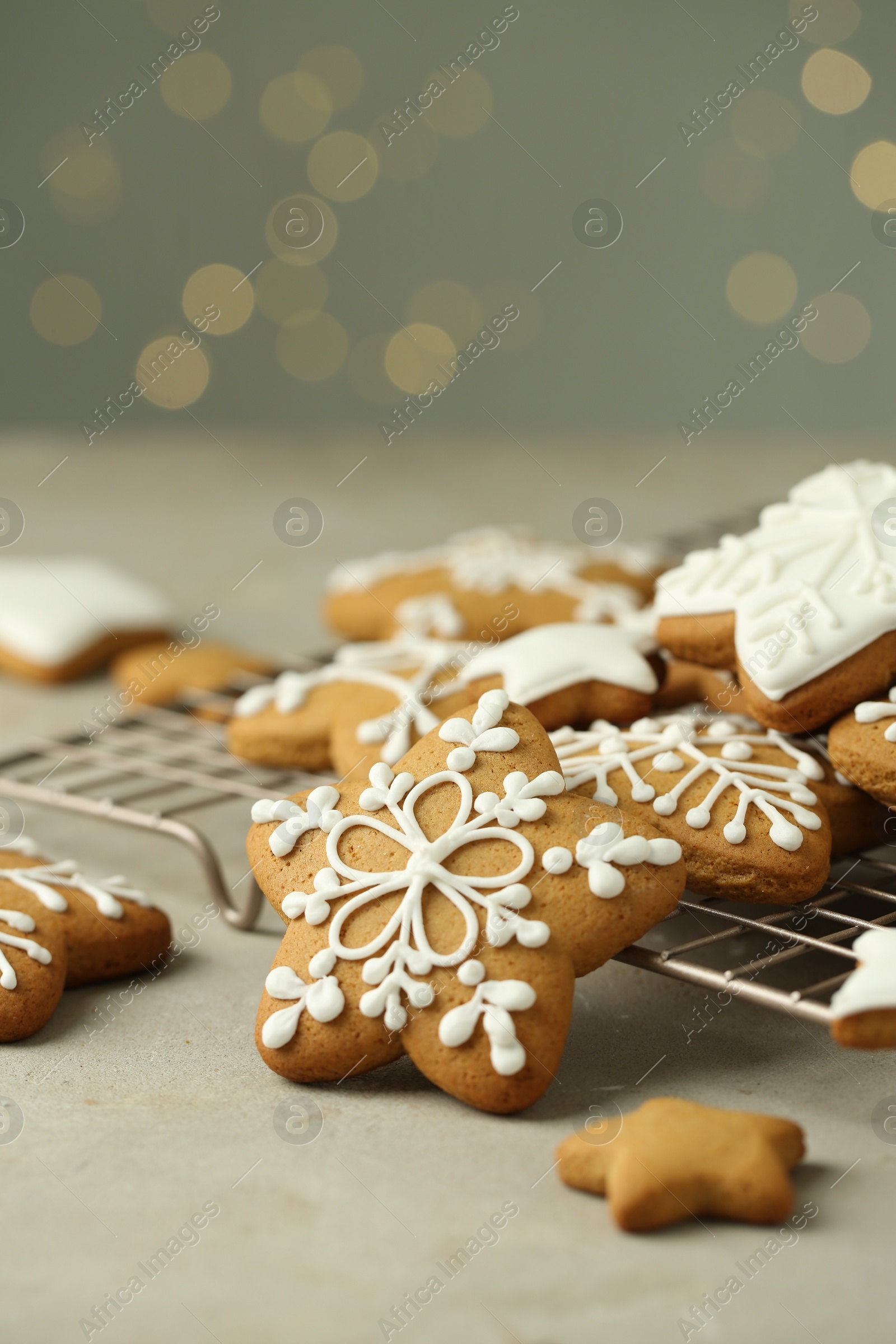 Photo of Tasty Christmas cookies with icing on table against blurred lights