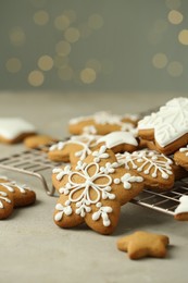 Photo of Tasty Christmas cookies with icing on table against blurred lights