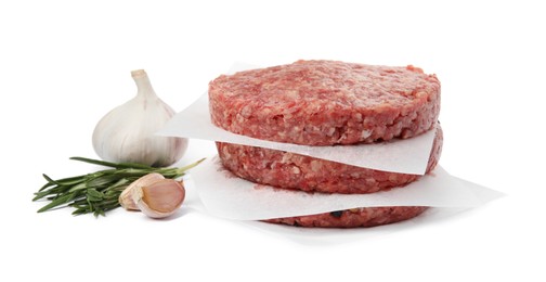 Raw hamburger patties with rosemary and garlic on white background