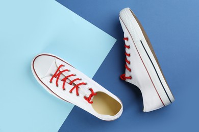 Pair of trendy sneakers on color background, flat lay