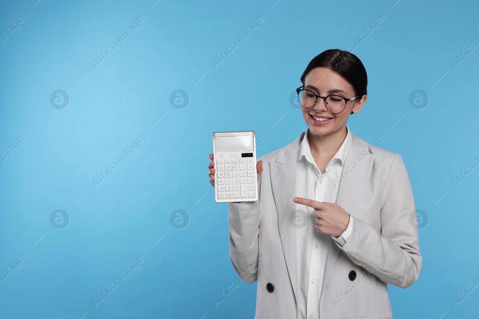 Photo of Smiling accountant with calculator on light blue background, space for text