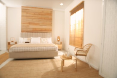 Photo of Blurred view of stylish hotel room interior with comfortable bed