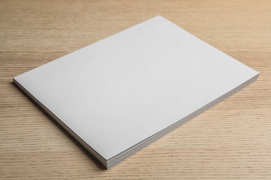 Photo of Brochure with blank cover on wooden background. Mock up for design