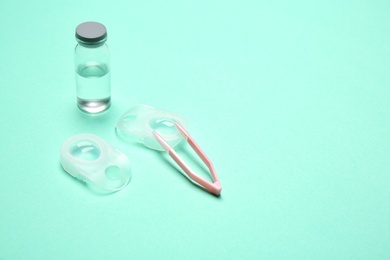 Photo of Contact lenses and accessories on color background