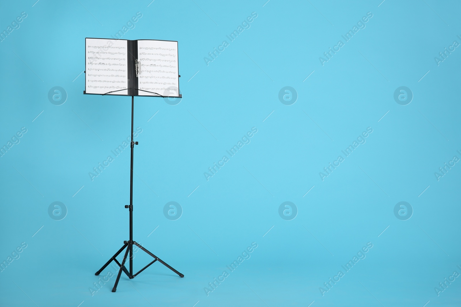 Photo of Note stand with music sheets on color background. Space for text