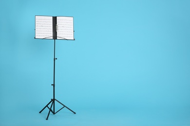 Note stand with music sheets on color background. Space for text