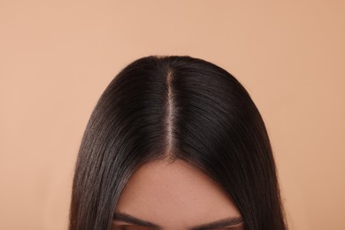 Photo of Woman with healthy hair on beige background, closeup