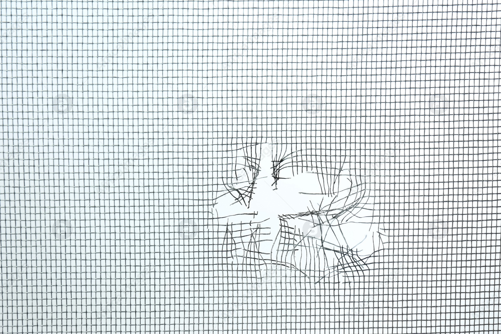 Photo of Torn window screen against white background, closeup