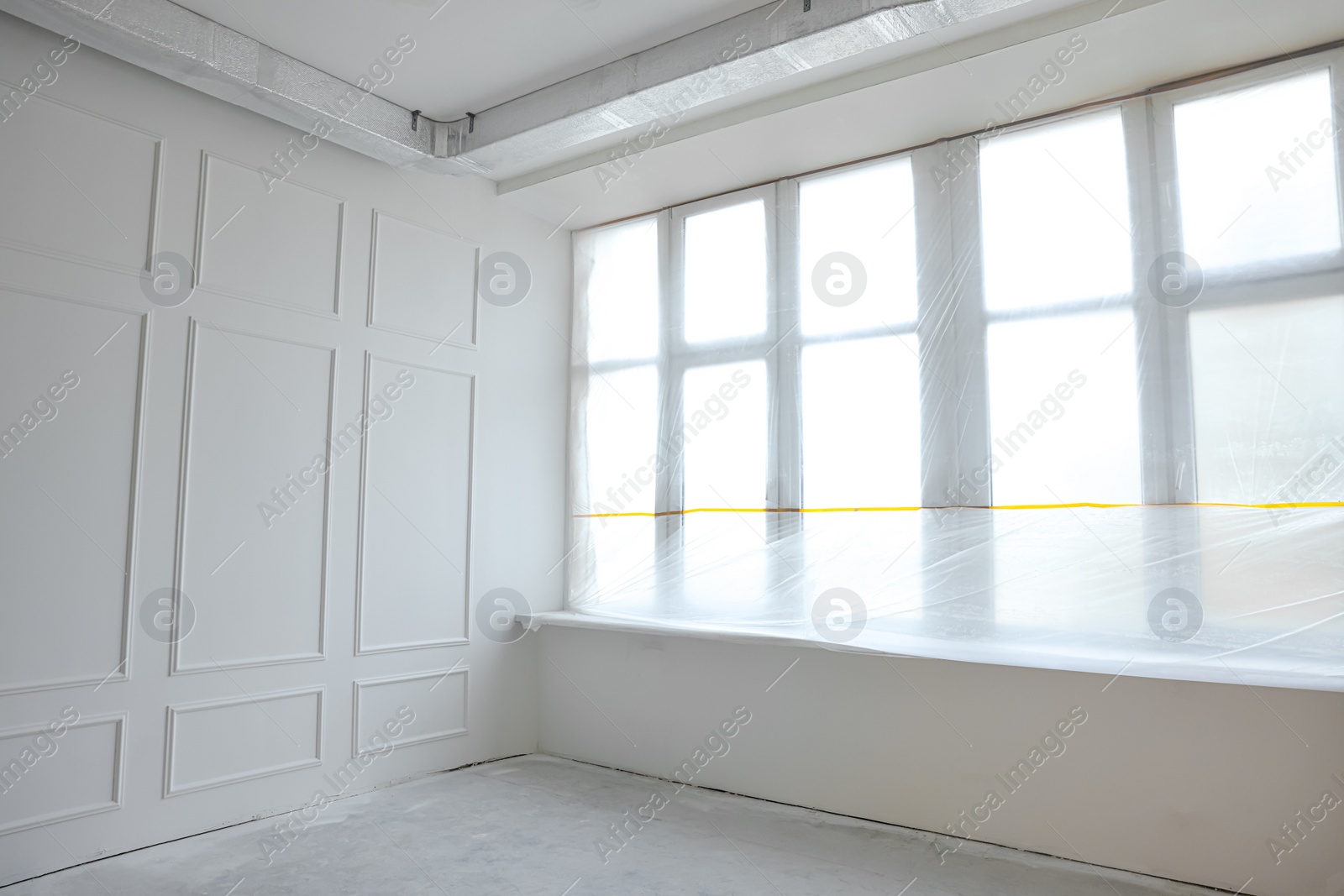 Photo of Window covered with plastic film in room after renovation