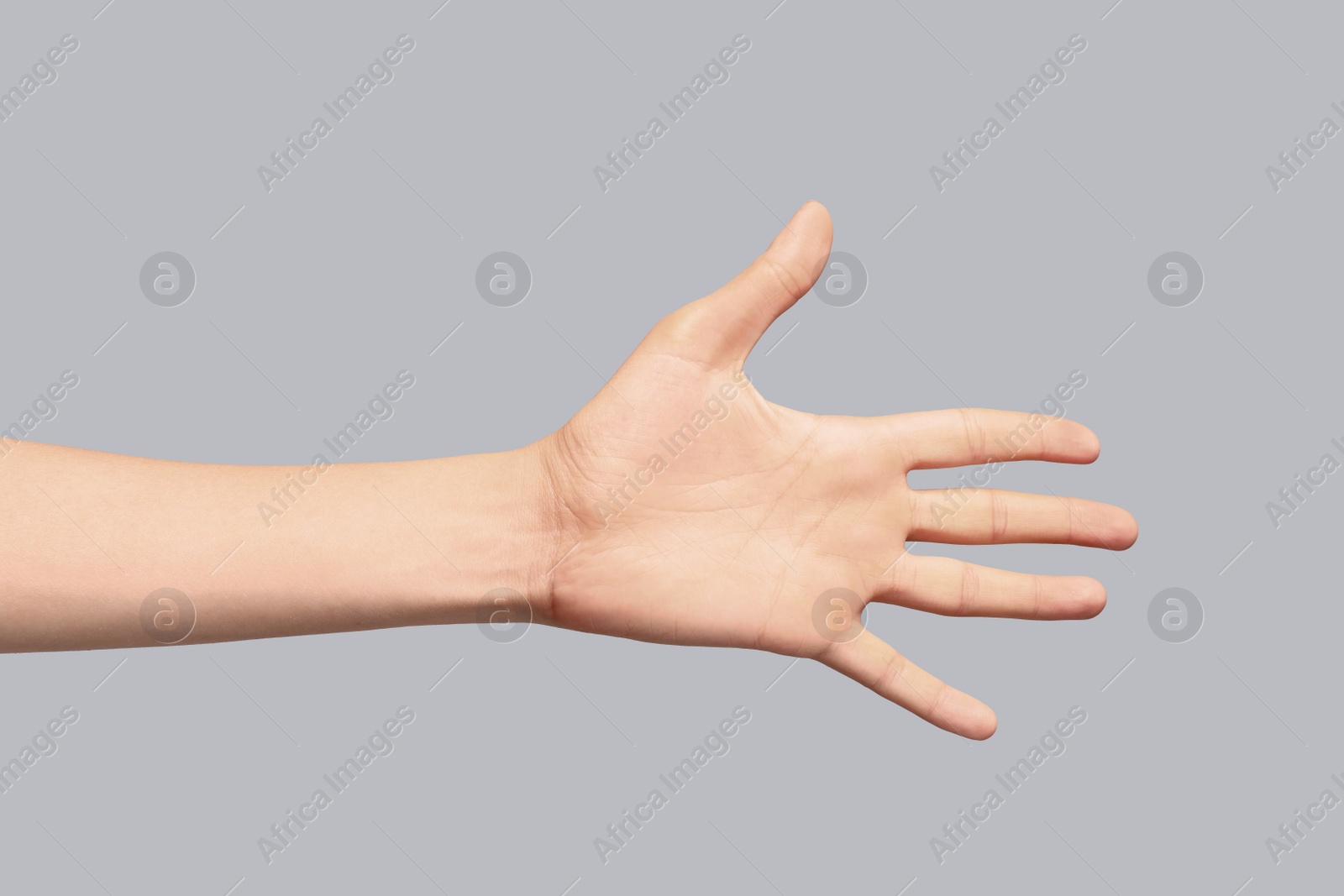 Photo of Young woman showing hand on grey background, closeup