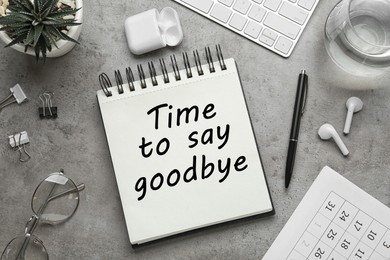 Image of Notebook with text Time to say goodbye on grey table, flat lay