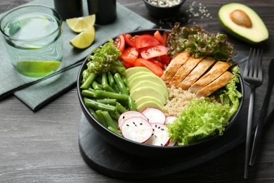 Photo of Healthy meal. Tasty products in bowl on black wooden table