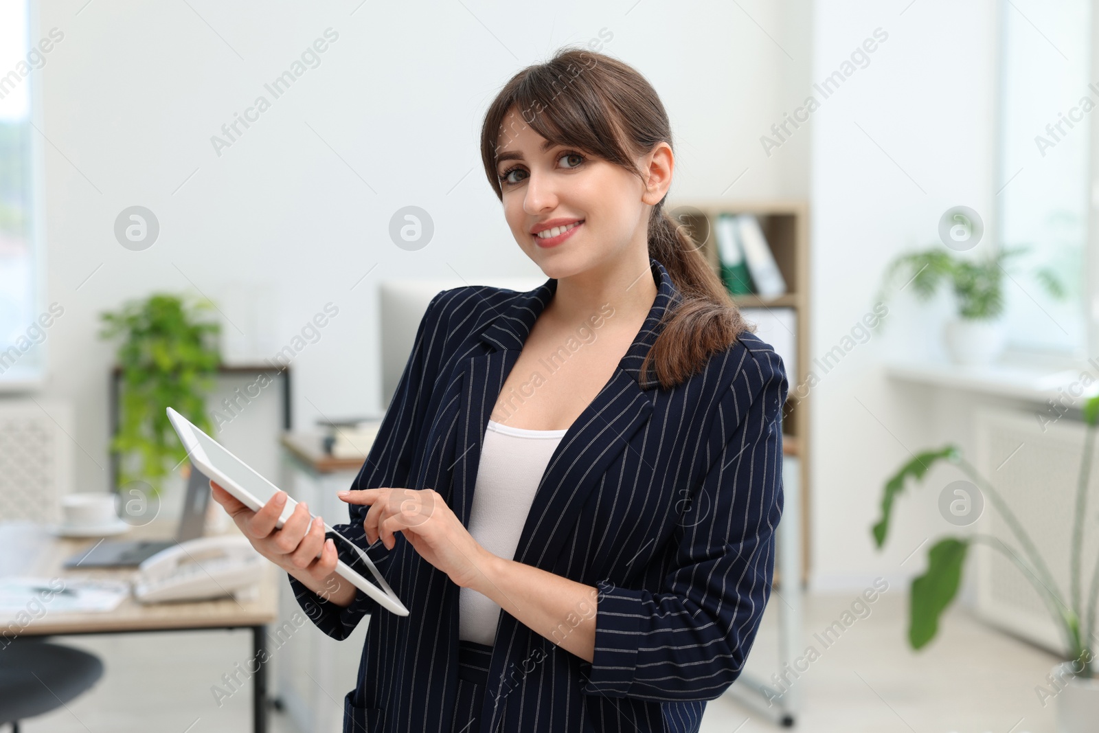 Photo of Portrait of smiling secretary with tablet in office