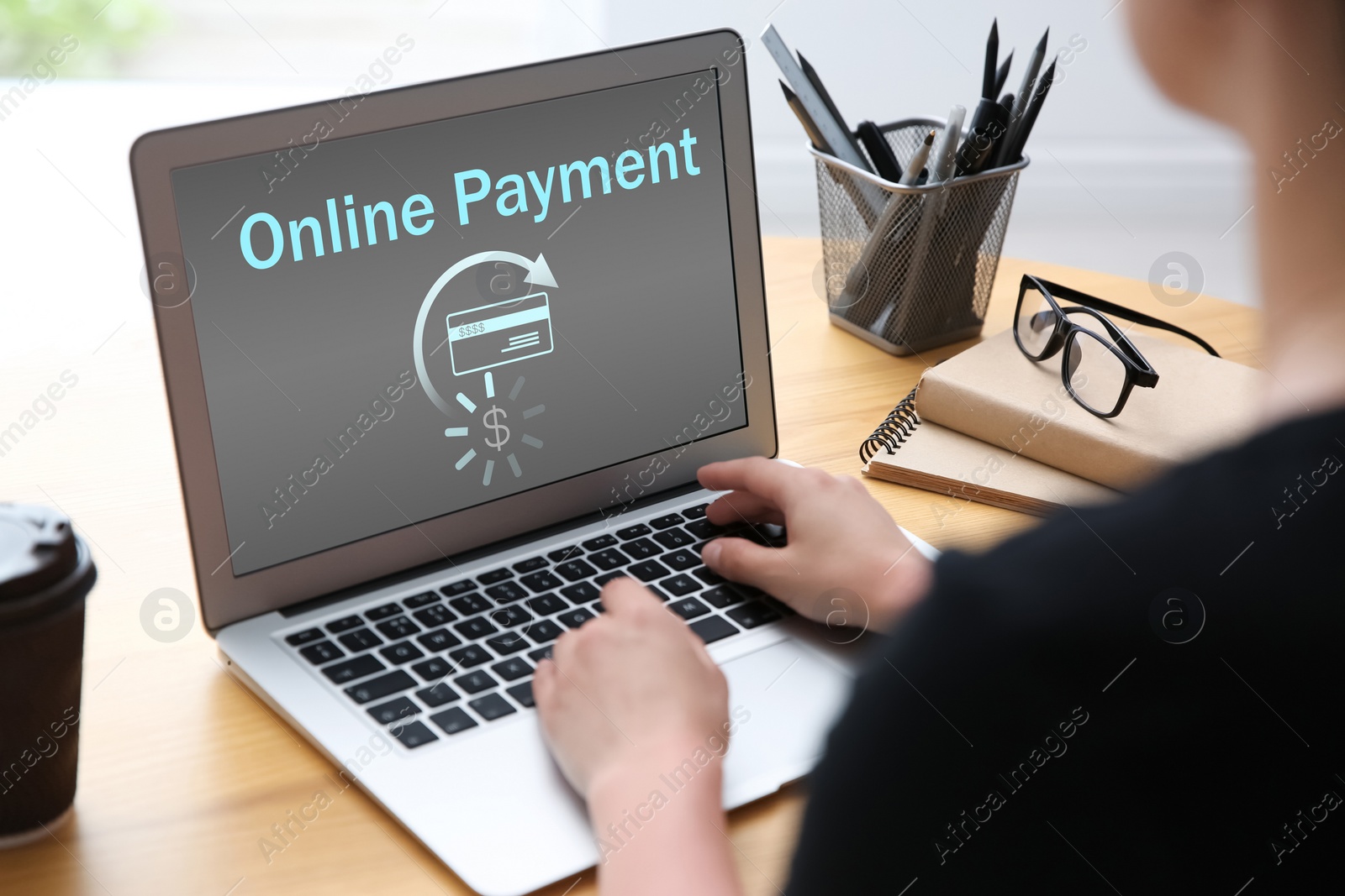 Image of Woman using laptop for online payment at wooden table, closeup