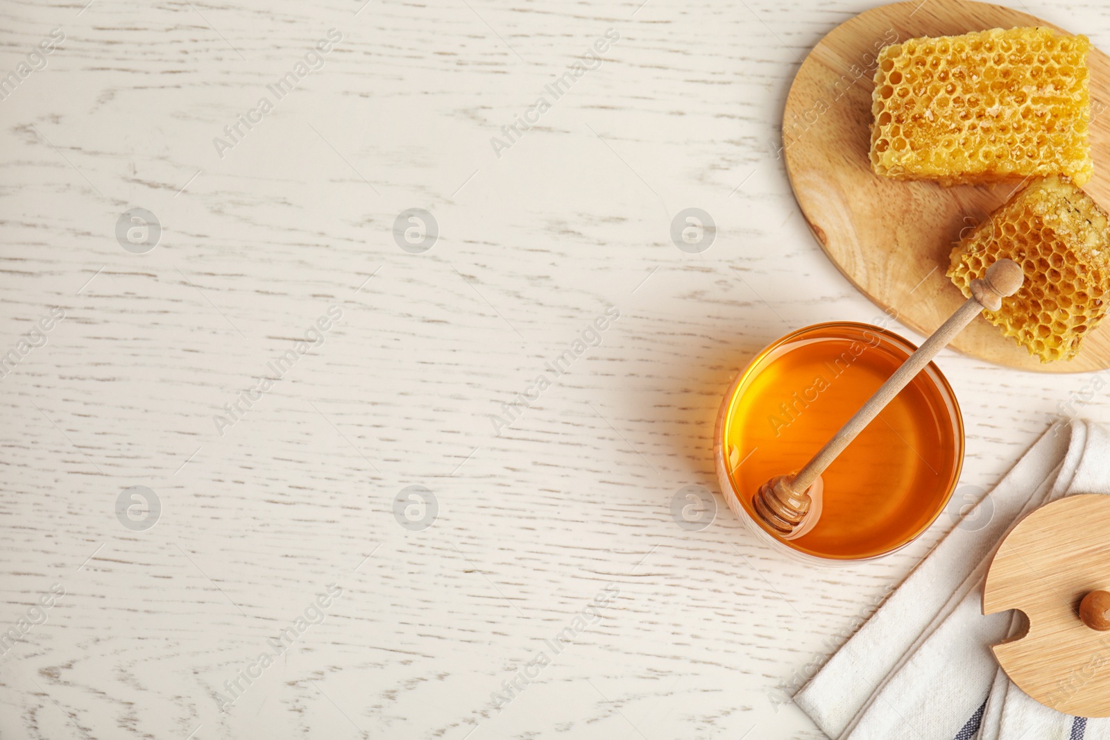 Photo of Flat lay composition with delicious honey on white wooden table. Space for text