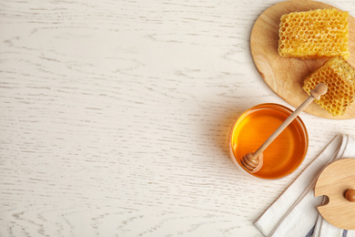 Photo of Flat lay composition with delicious honey on white wooden table. Space for text