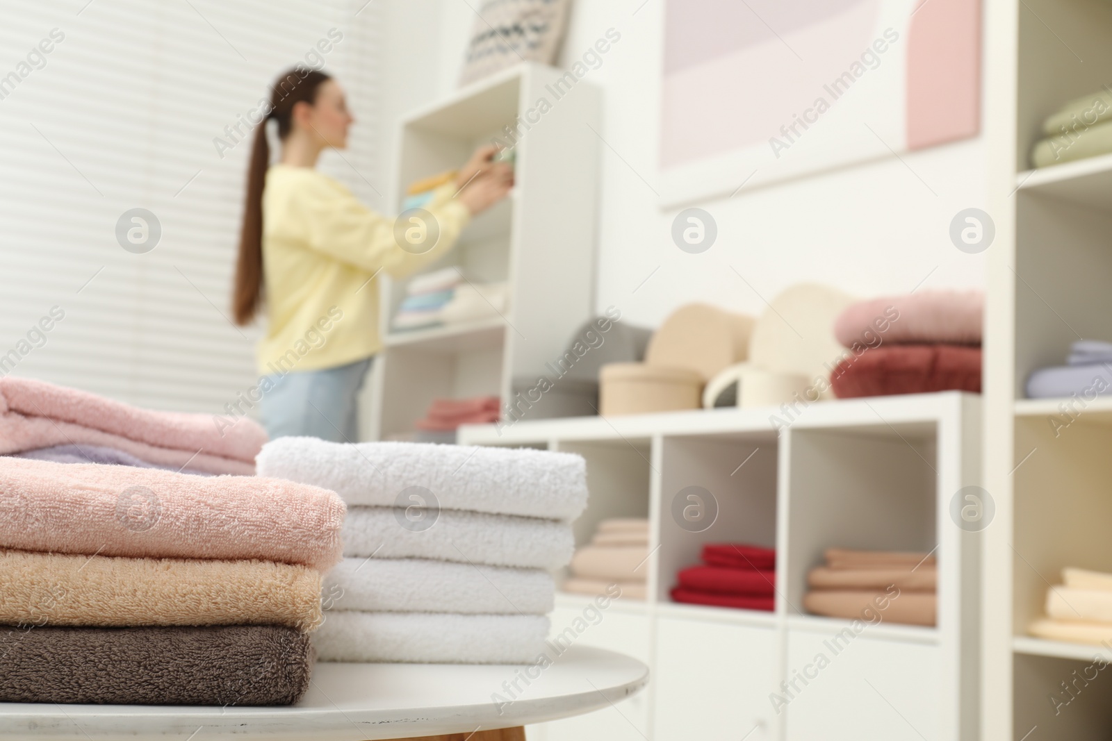 Photo of Stack of new towels on display in home textiles store, closeup. Space for text